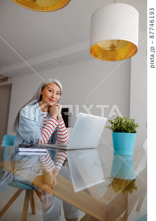 Woman using modern notebook in living room 87746193