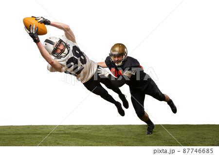 Two male american football players playing during sport match on grass flooring isolated on white background. Concept of sport, challenges, goals, strength. Poster, banner for ad 87746685