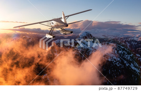 Single Engine Seaplane Flying over the Rocky Mountain Landscape. 87749729