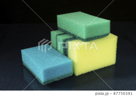 Sponge for dishwashing on glass table on black background 87750391