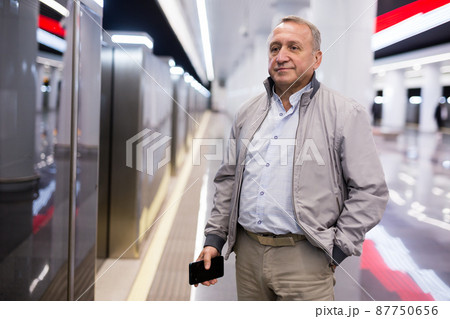Middle aged man waiting for train in subway station 87750656