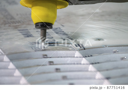 Closeup scene the multi-axis waterjet cutting machine with NC code data background. 87751416