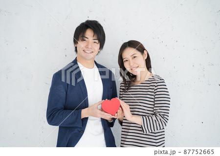 ハートを持つ笑顔の男女 87752665