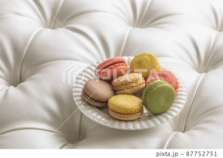 Assortment of macaroons in white plate on white leather furniture Assortment of macaroons in white plate on white leather furniture 87752751