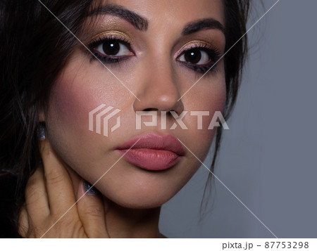 Beautiful brunet model woman face with brown eyes and perfect make-up . Portrait of beauty young brunet girl with pink lips. Female face with clear skin close-up. Skincare Beautiful brunet model woman face with brown eyes and perfect make-up . Portrait of beauty young brunet girl with pink lips. Female face with clear skin close-up. Skincare 87753298