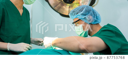 Asian Professional surgeons team performing surgery in the operating room, surgeon, Assistants, and Nurses Performing Surgery on a Patient, health care cancer and disease treatment concept Asian Professional surgeons team performing surgery in the operating room, surgeon, Assistants, and Nurses Performing Surgery on a Patient, health care cancer and disease treatment concept 87753768