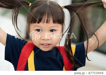 Portrait of happy and funny Asian child girl on white background, a child looking at camera. Preschool kid dreaming fill with energy feeling healthy and good concept 87753949