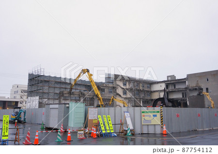老朽化した公共建造物の解体作業をする重機 老朽化した公共建造物の解体作業をする重機 87754112