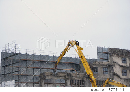 老朽化した公共建造物の解体作業をする重機 老朽化した公共建造物の解体作業をする重機 87754114