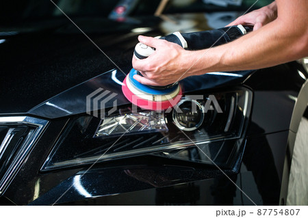 Close up of car detailist hands, cleaning or pilishing the car by poliermaschine, car detailing concept, orbital polisher in repair shop polishing car 87754807