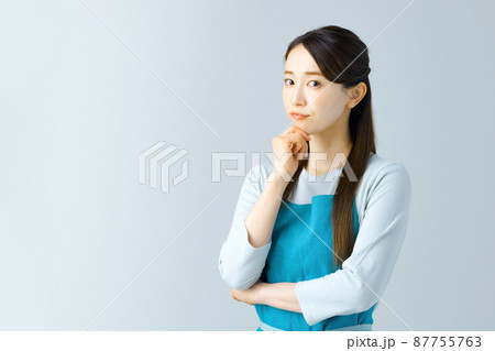 考え込むエプロン姿の若い主婦 87755763