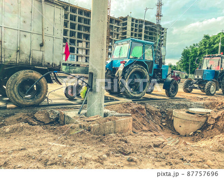 construction of a new residential complex in the city center. high houses made of concrete and glass for people's lives. construction equipment and tractors are driving nearby 87757696