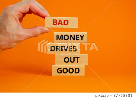 Business concept growth success process. Wood blocks on orange background, copy space. Businessman hand. Words 'bad money drives out good'. Conceptual image of motivation. 87758301
