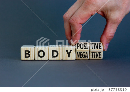 Body positive or negative symbol. Psychologist turns cubes, changes words body negative to body positive. Beautiful grey background, copy space. Psychological, body positive or negative concept. 87758319