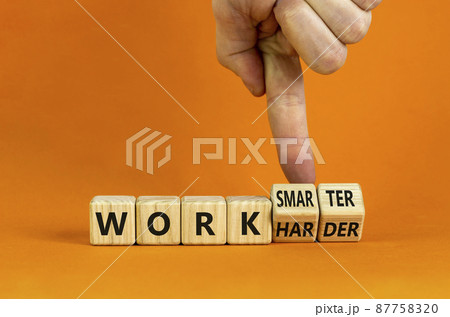 Work harder or smarter symbol. Businessman turns wooden cubes and changes words 'work harder' to 'work smarter'. Beautiful orange background, copy space. Business and work harder or smarter concept. Work harder or smarter symbol. Businessman turns wooden cubes and changes words 'work harder' to 'work smarter'. Beautiful orange background, copy space. Business and work harder or smarter concept. 87758320