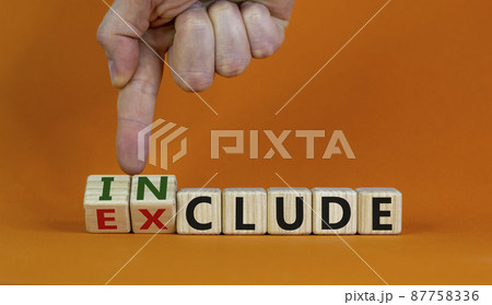Symbol for a better inclusion. Male hand turns wooden cubes and changes word exclude to include. Beautiful orange background. Copy space. Better inclusion concept. 87758336