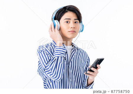 ヘッドホンで音楽を聴く若い男性   白バック 87758750