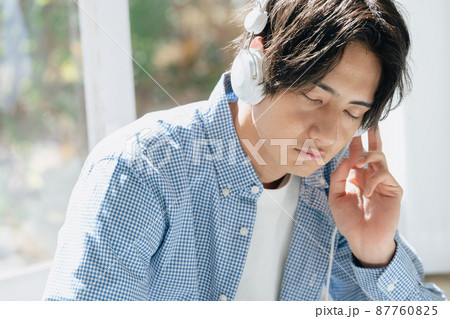 音楽を聞く若い男性 87760825