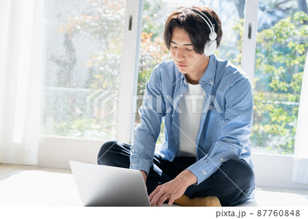 音楽を聞く若い男性 87760848