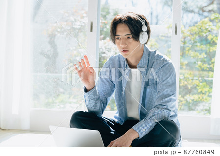 音楽を聞く若い男性 87760849