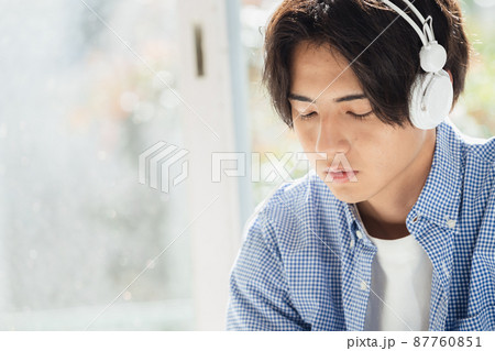 音楽を聞く若い男性 87760851