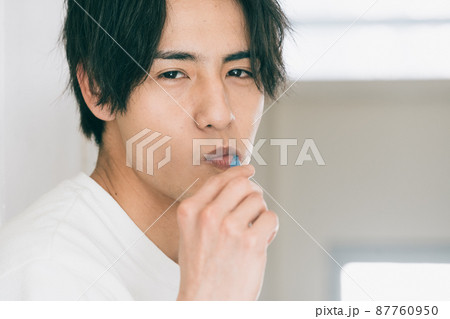 歯磨きをする若い男性 87760950