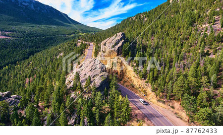 Road through large boulder in the mountains of pine trees Road through large boulder in the mountains of pine trees 87762433