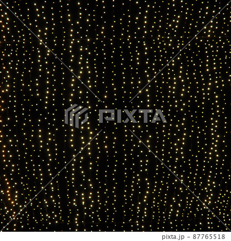 Hanging garlands against the background of the night sky. Festive decoration of city streets. Garlands of yellow, white and gold lights and bulbs. Beautiful background for New Year, Christmas holiday. 87765518