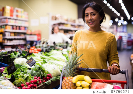 Smiling latin american woman enjoying shopping in store Smiling latin american woman enjoying shopping in store 87766575