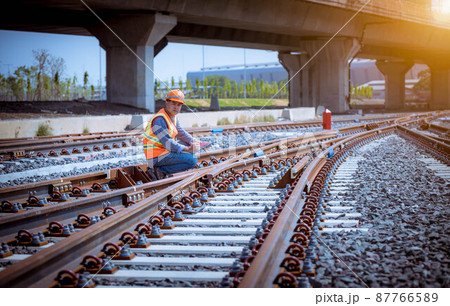 Engineer under discussion inspection and checking construction process railway switch and checking work on railroad station .Engineer wearing safety uniform and safety helmet in work. 87766589