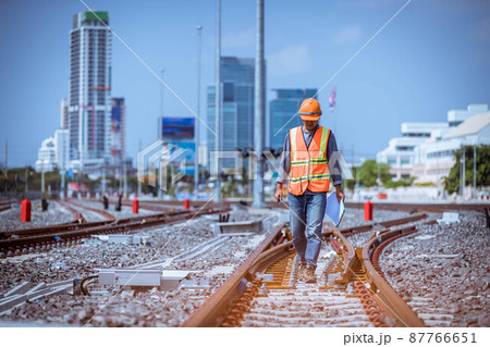 Engineer under discussion inspection and checking construction process railway switch and checking work on railroad station .Engineer wearing safety uniform and safety helmet in work. 87766651