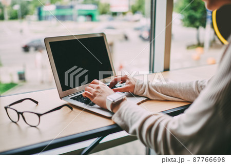 Busy person typing on laptop during workday Busy person typing on laptop during workday 87766698