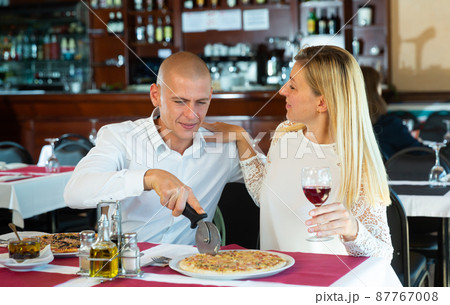 Loving cheerful positive pair enjoying pizza and conversation at restaurant 87767008