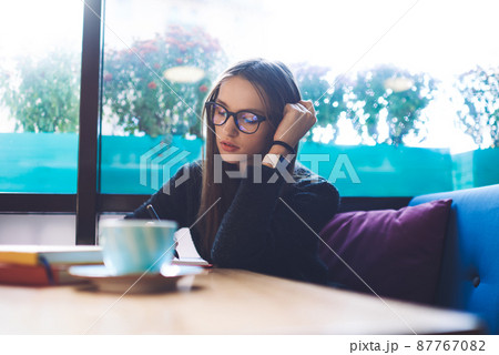 Wistful woman writing notes in notepad 87767082
