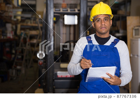 Warehouse manager calculates the quantity of goods and writes it down in notebook Warehouse manager calculates the quantity of goods and writes it down in notebook 87767336