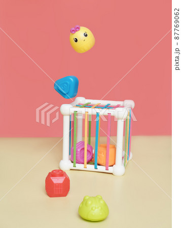 baby educational toy. a multi-colored cube. Development of fine motor skills and logical thinking, levitating pieces of a toy, red background 87769062