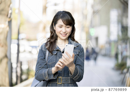 スマートフォンを持ったアラフィフの女性 87769899