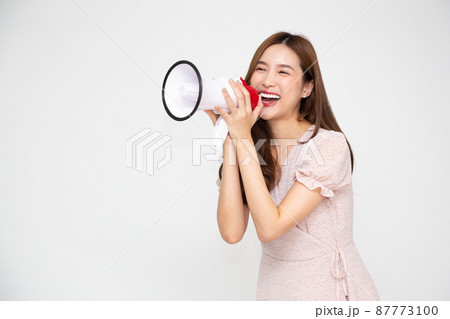 Young Asian woman holding megaphone isolated on white background, Speech and announce concept 87773100