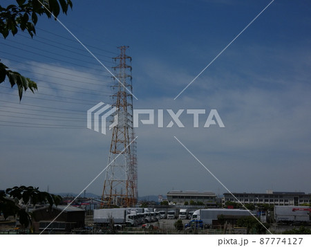 夏の日をバックに遠くまで続く送電線と鉄塔 87774127