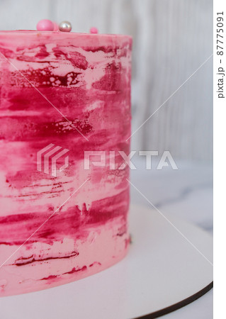 Side view of colorful pink birthday cake. Party celebration concept Modern stylish sweet cake Side view of colorful pink birthday cake. Party celebration concept Modern stylish sweet cake 87775091
