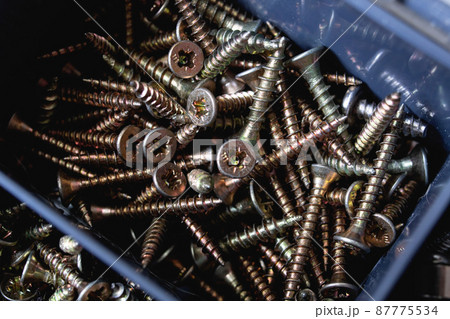 Various screws in plastic box close up 87775534