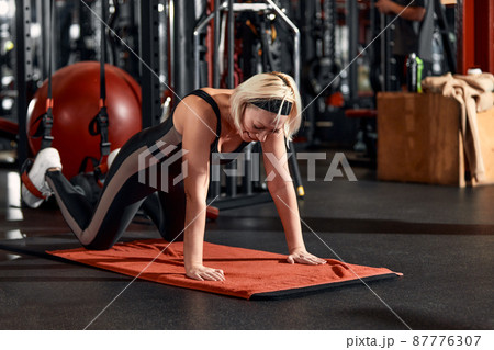 Young and active people on group sports training together do warming up and doing exercise for arm stretch. People train in spacious bright gym. Concept of sport and healthy lifestyle 87776307