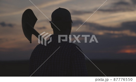 silhouette of farmer with shovel field, agriculture, gardening business spring work, summer sunset on rural land, harvest time, man gardener goes dig land on plantation, work soil farm agronomist 87776550