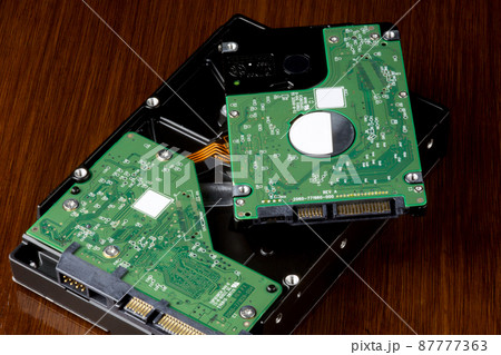 Computer Hard Drives on a Wooden Table Top 87777363