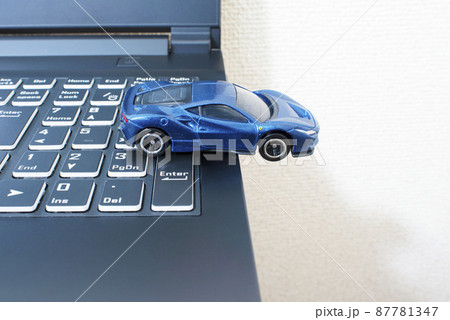 黒いパソコンのキーボードの上で単独事故を起こして脱輪している青いスポーツカー 黒いパソコンのキーボードの上で単独事故を起こして脱輪している青いスポーツカー 87781347