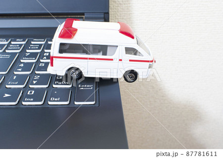 黒いパソコンのキーボードの上で単独事故を起こして脱輪している日本の救急車 87781611