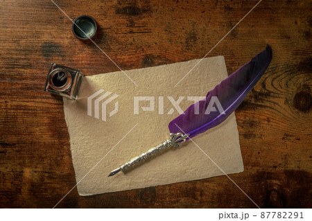 A quill pen with a vintage ink well and old parchment paper A quill pen with a vintage ink well and old parchment paper 87782291