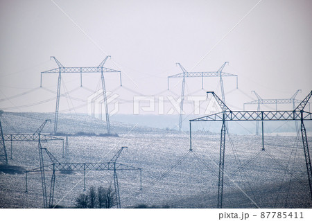 Steel pillar with high voltage electric power lines delivering electrical energy through cable wires on long distance 87785411