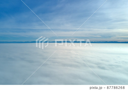 Aerial view from high altitude of earth covered with white puffy cumulus clouds on sunny day 87786268