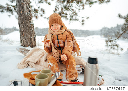 LIttle boy on a picnic in winter forest LIttle boy on a picnic in winter forest 87787647